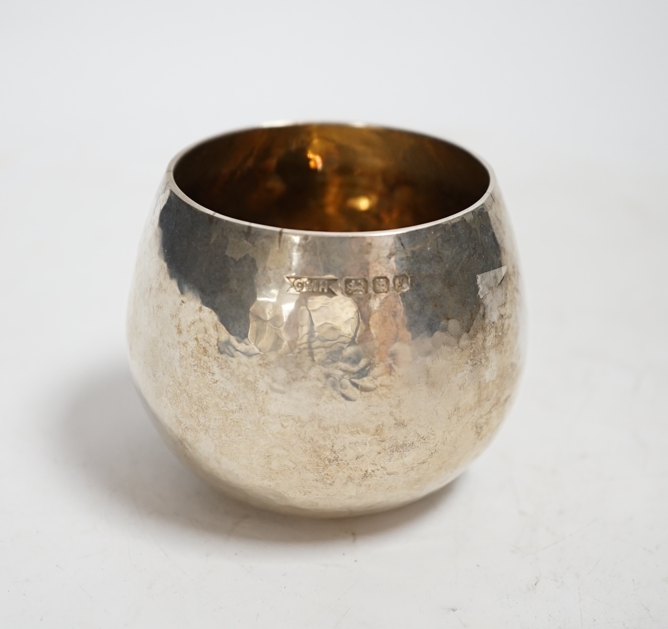 An Elizabeth II planished silver bowl with gilded interior, maker, C.M.H, London, 1985, height 57mm, 3.9oz.